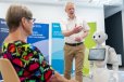 Interaktion Mensch - Roboter. Simulationspatientin im Dialog mit dem sozialen Pflegeroboter Pepper zum Trinkverhalten. Der BTU-Pflegewissenschaftler Jörg Matthäi gibt Erläuterungen. 